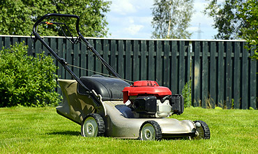 Professional lawn mower on freshly cut green grass — weekly lawn mowing services in Mount Airy NC